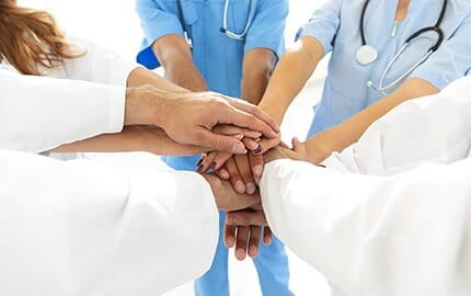 Cinq professionnels de santé se rassemblent et s'entraident main dans la main en vue d'améliorer la qualité de vie au travail.
