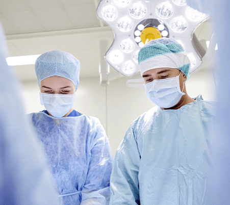 Deux médecins en tenue chirurgicale prêts à collaborer dans un bloc opératoire.