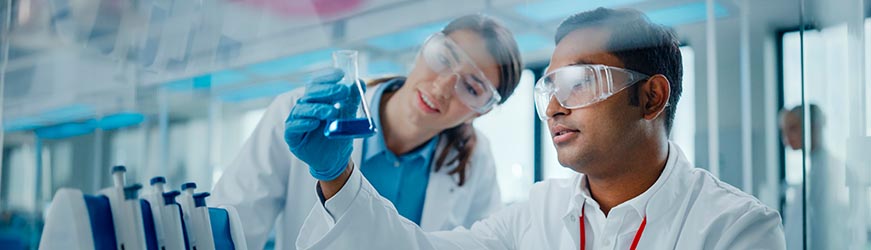 Un homme et une femme travaillant dans un laboratoire analysent une fiole contenant un liquide