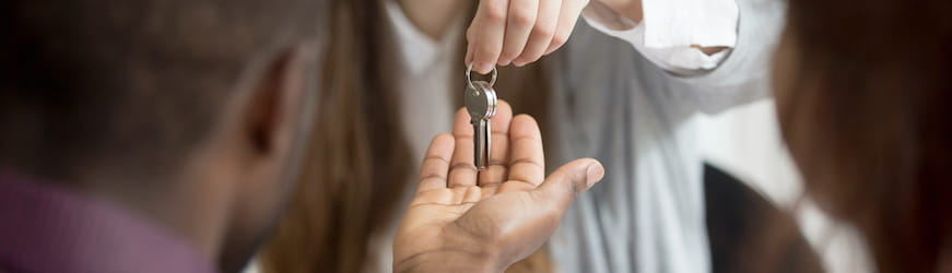 Un jeune homme reçoit les clés de l'appartement temporaire où il habitera le temps de son CDD en déplacement 