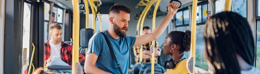 Un jeune homme et une jeune femme discute pendant un trajet en bus jusqu’à leur travail