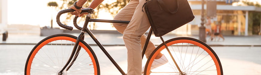 Un jeune homme avec une sacoche en bandoulière, qui se rend au travail en vélo.