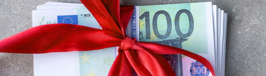 Des billets rassemblés par un ruban cadeau qui figurent la prime de fin d’année touchées par certain·es salarié·es