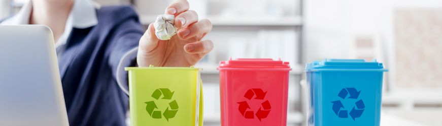 Une salariée qui trie ses déchets à son travail, dans 3 poubelles de couleurs différentes. 