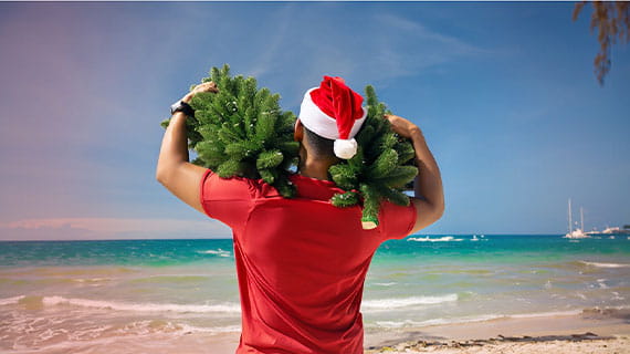 Père Noël en tee-shirt à la plage, avec des sapins sur les épaules. Gagnez du temps, recrutez dès maintenant pour la saison d’hiver.
            
