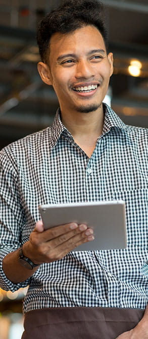 : homme souriant, sur une tablette, profite de l’accompagnement du Réseau Adecco Inclusion