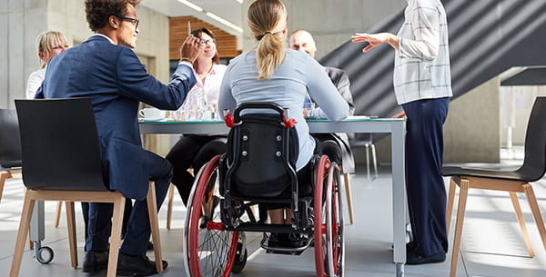 Scène de travail dans un bureau incluant une personne à mobilité réduite