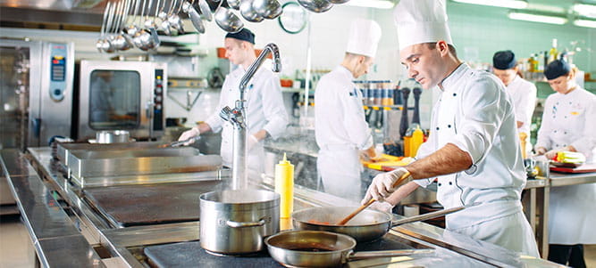 chefs, commis de cuisine, chefs exécutifs s’affairent dans les cuisines d’un restaurant
