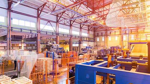 Photo d'un entrepôt, dans lequel il y a des palettes de bois ainsi que des machines.