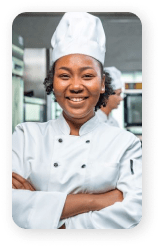 Une jeune femme afro-américaine souriante en tenue de cuisinier