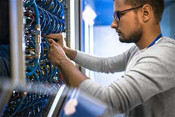 technicien intervient dans un entrepôt pour réparer des problèmes réseau